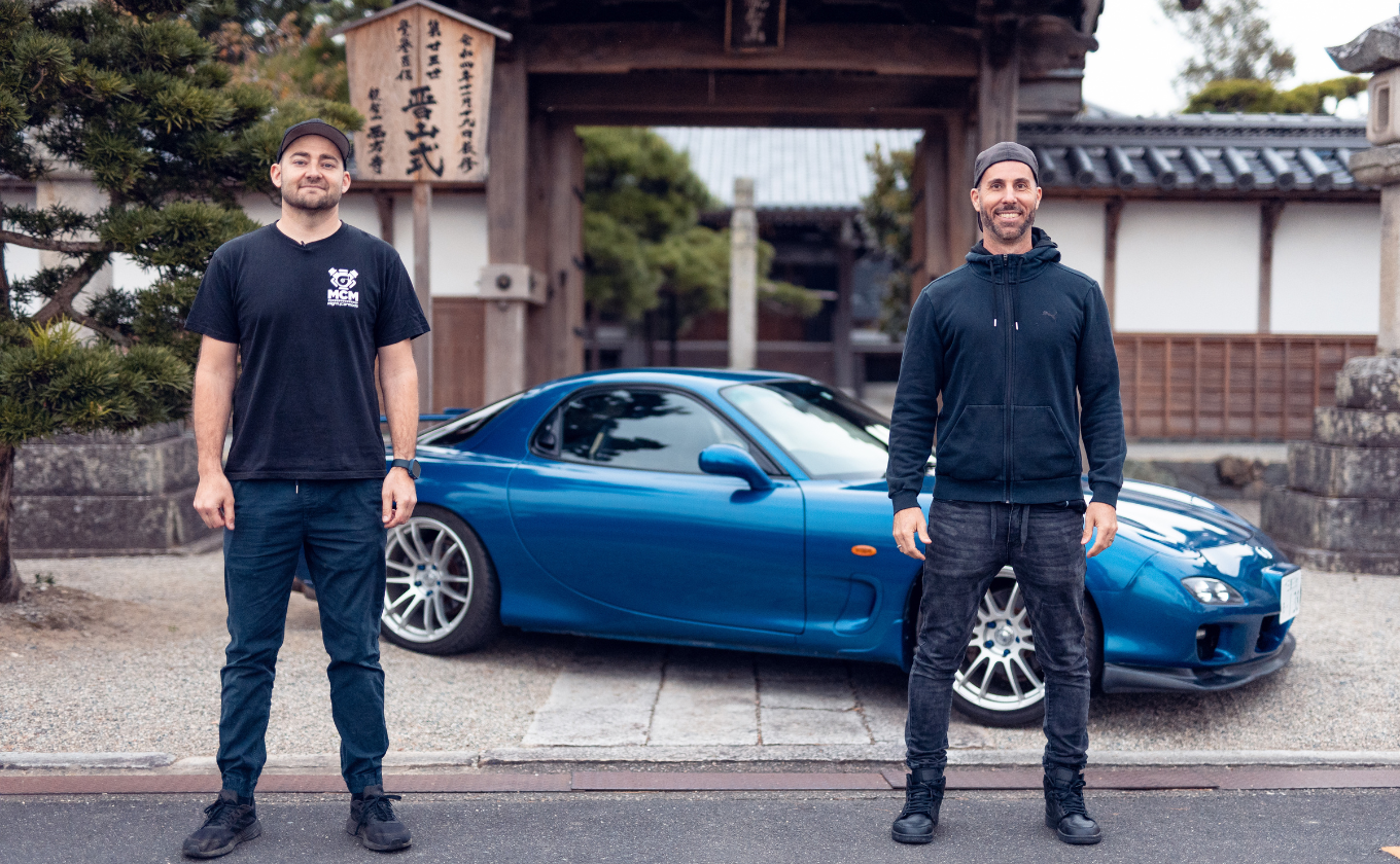 Marty and Moog in front of blue Mazda RX-7