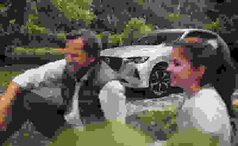 Family enjoying life picnicing with the CX 60 thanks to Mazda Assured
