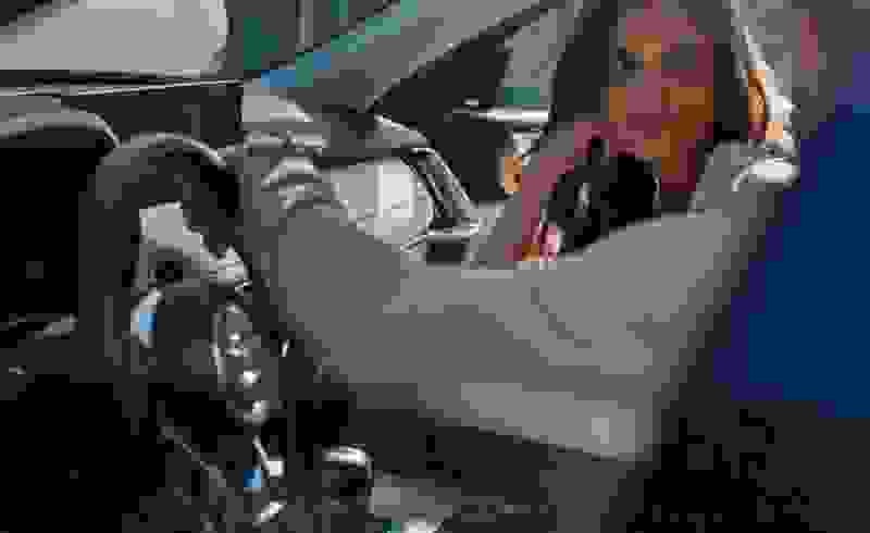 A woman confidently sits in the driver's seat of her Mazda, ready to take control of the road ahead.