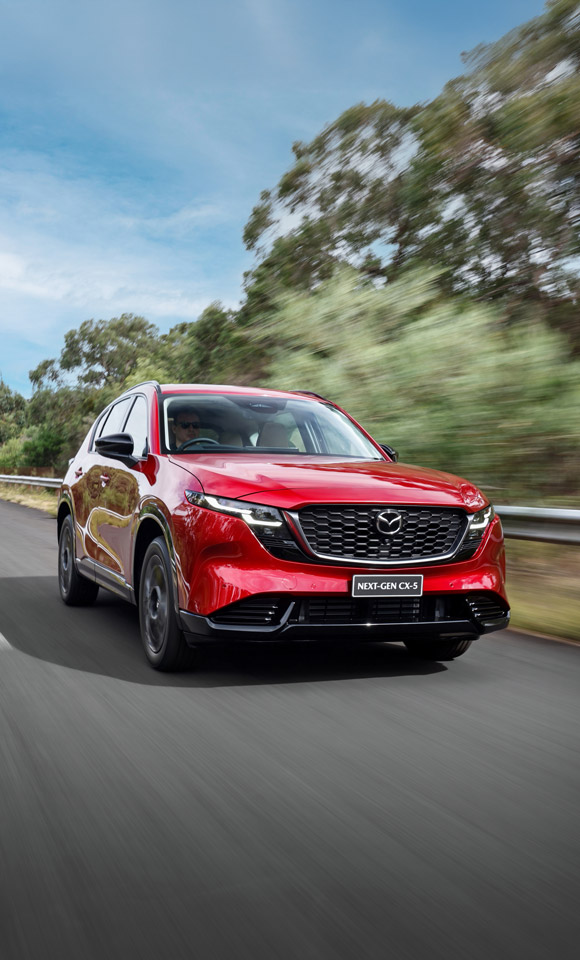 Next-Gen Mazda CX-5 driving along the road with blue skies