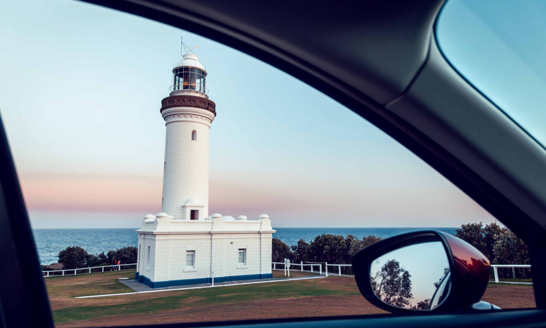 Norah Head Lighthouse viewed through the side window of the Mazda CX-90 at dusk