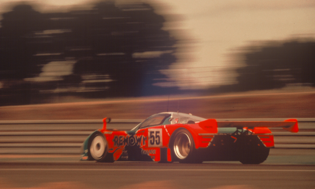 Mazda 787B No.55 in Renown livery racing at speed during the 1991 Le Mans 24 Hours, side view highlighting motion and endurance performance
