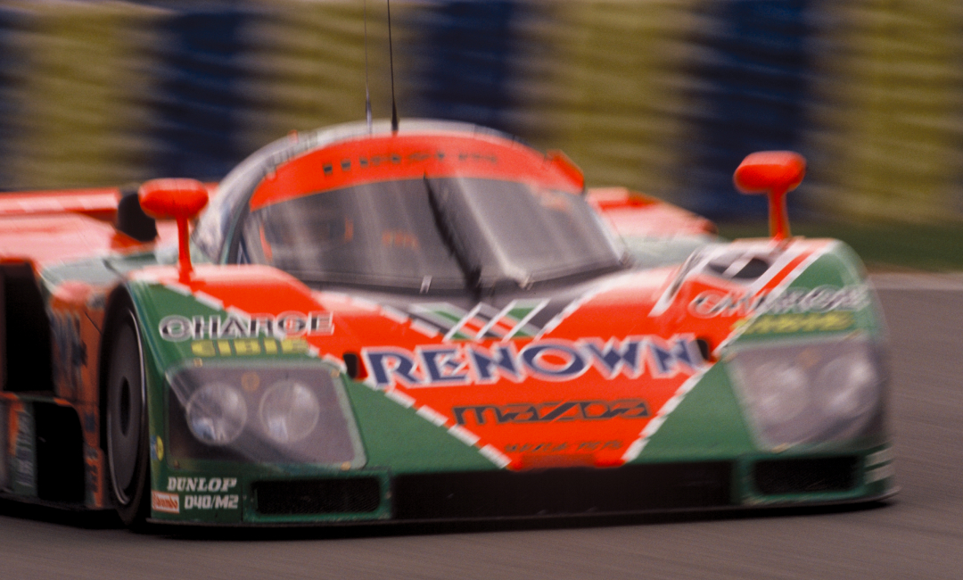 Mazda 787B No.55 in Renown livery racing at speed during the 1991 Le Mans 24 Hours, front view of the iconic rotary-powered endurance car in motion