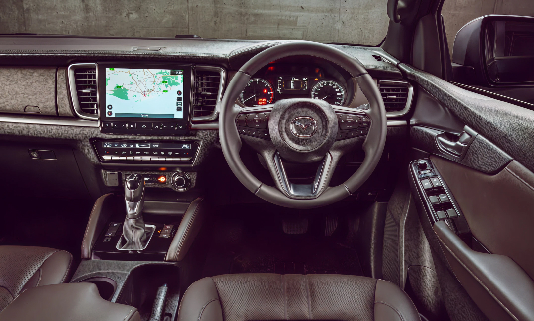 Modern Mazda BT-50 GT interior with a large central touchscreen and leather trim