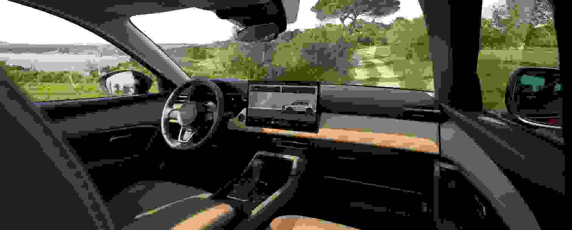 2026 Mazda CX-5 driver-focused interior with beige and black trim, large central touchscreen display, and scenic coastal view—modern SUV cockpit with advanced infotainment and premium design.