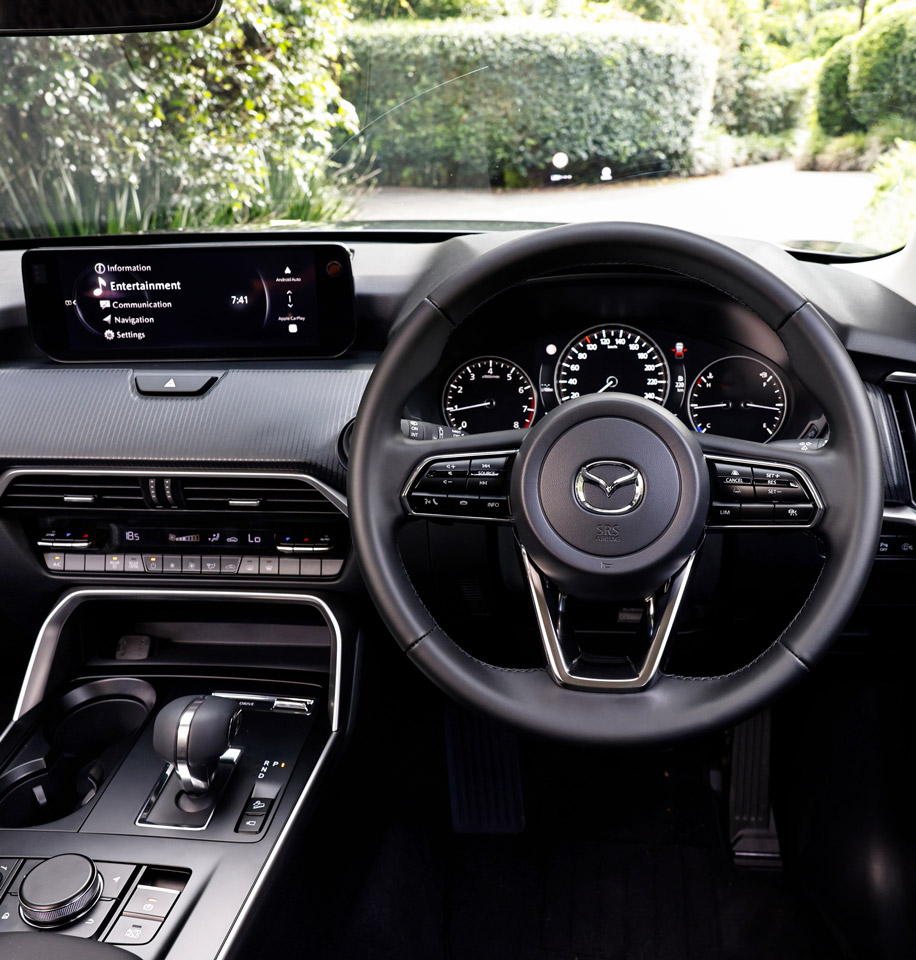 Driver’s cockpit of the Mazda CX-80 highlighting intuitive controls, digital infotainment system, and ergonomic layout designed to support safe, confident driving for families.