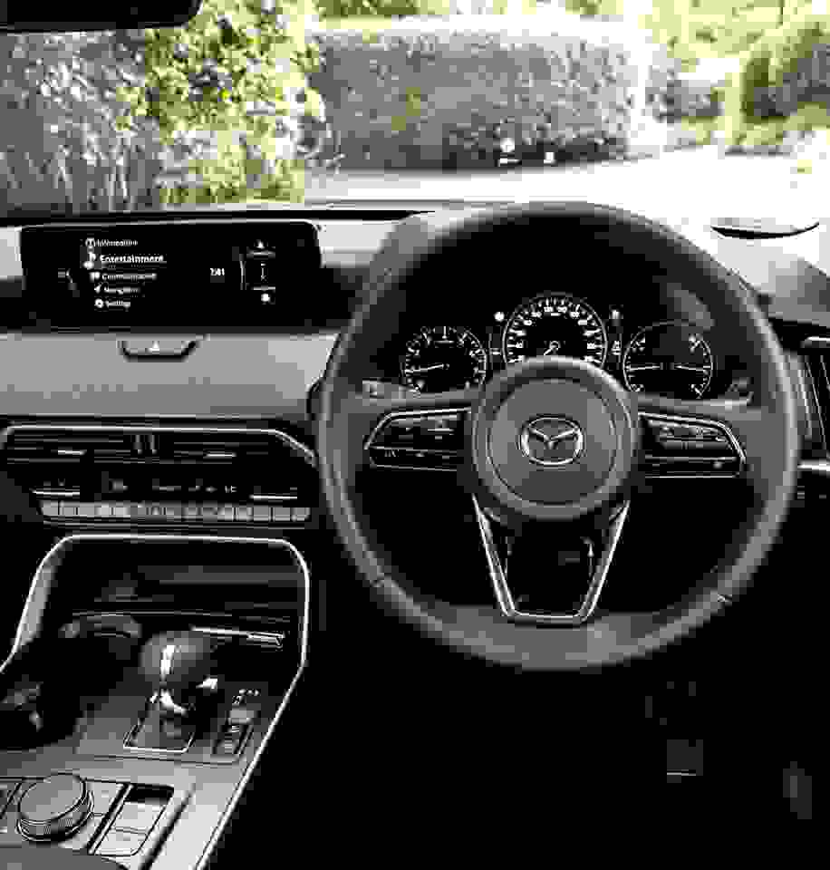 Driver’s cockpit of the Mazda CX-80 highlighting intuitive controls, digital infotainment system, and ergonomic layout designed to support safe, confident driving for families.