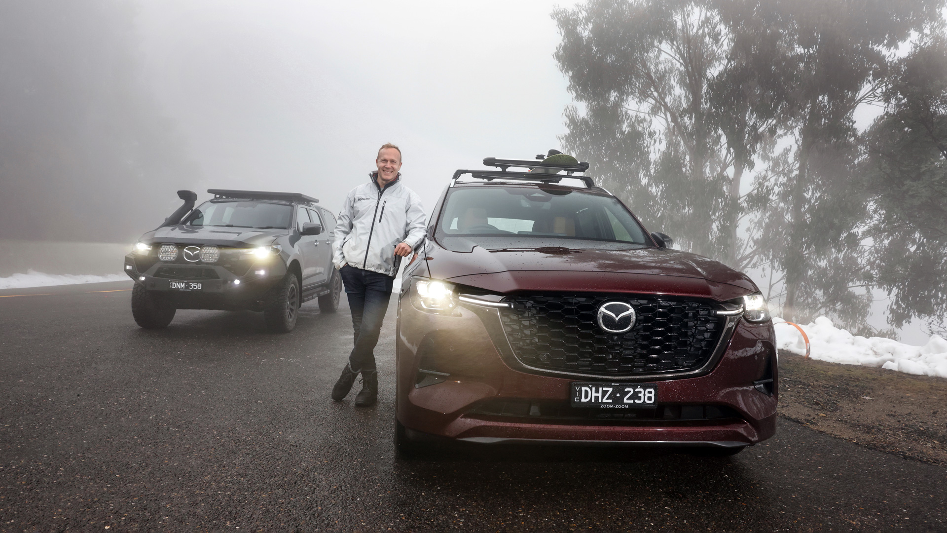 Mazda CX-80 & BT-50 on an alpine road with snow in the background