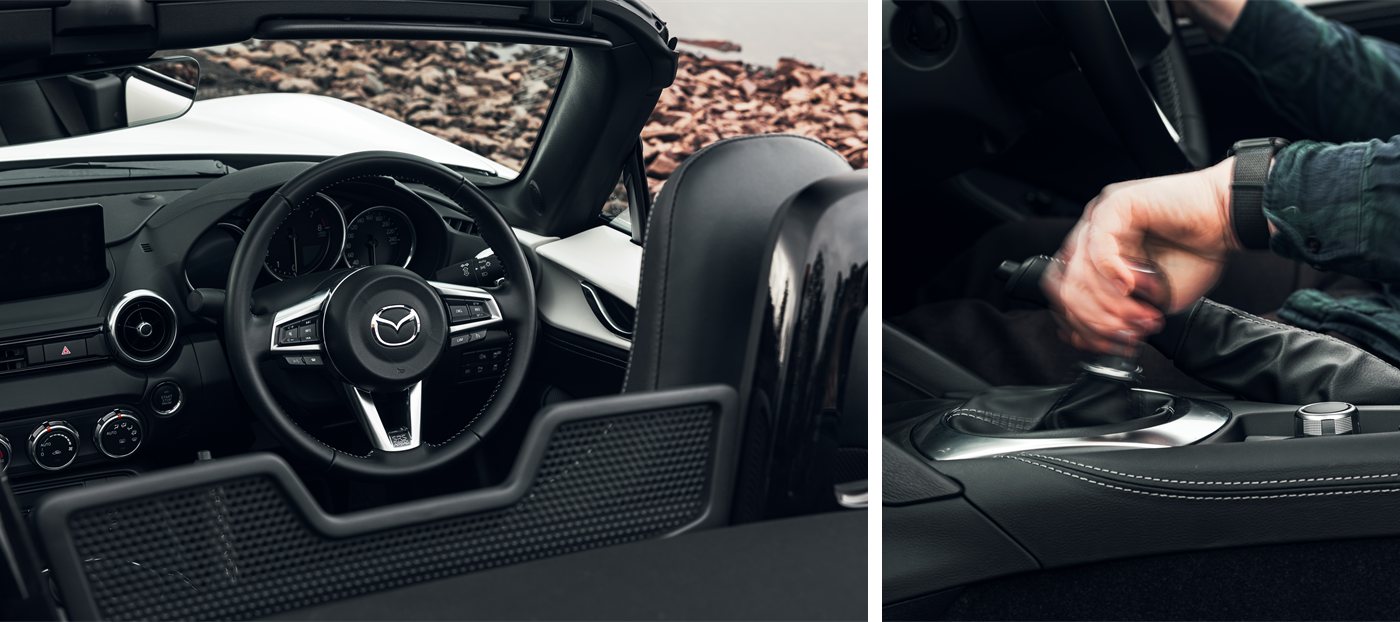Mazda MX-5 cabin &mdash; the leather steering wheel with Mazda badge, beside the six-speed manual gearshift.