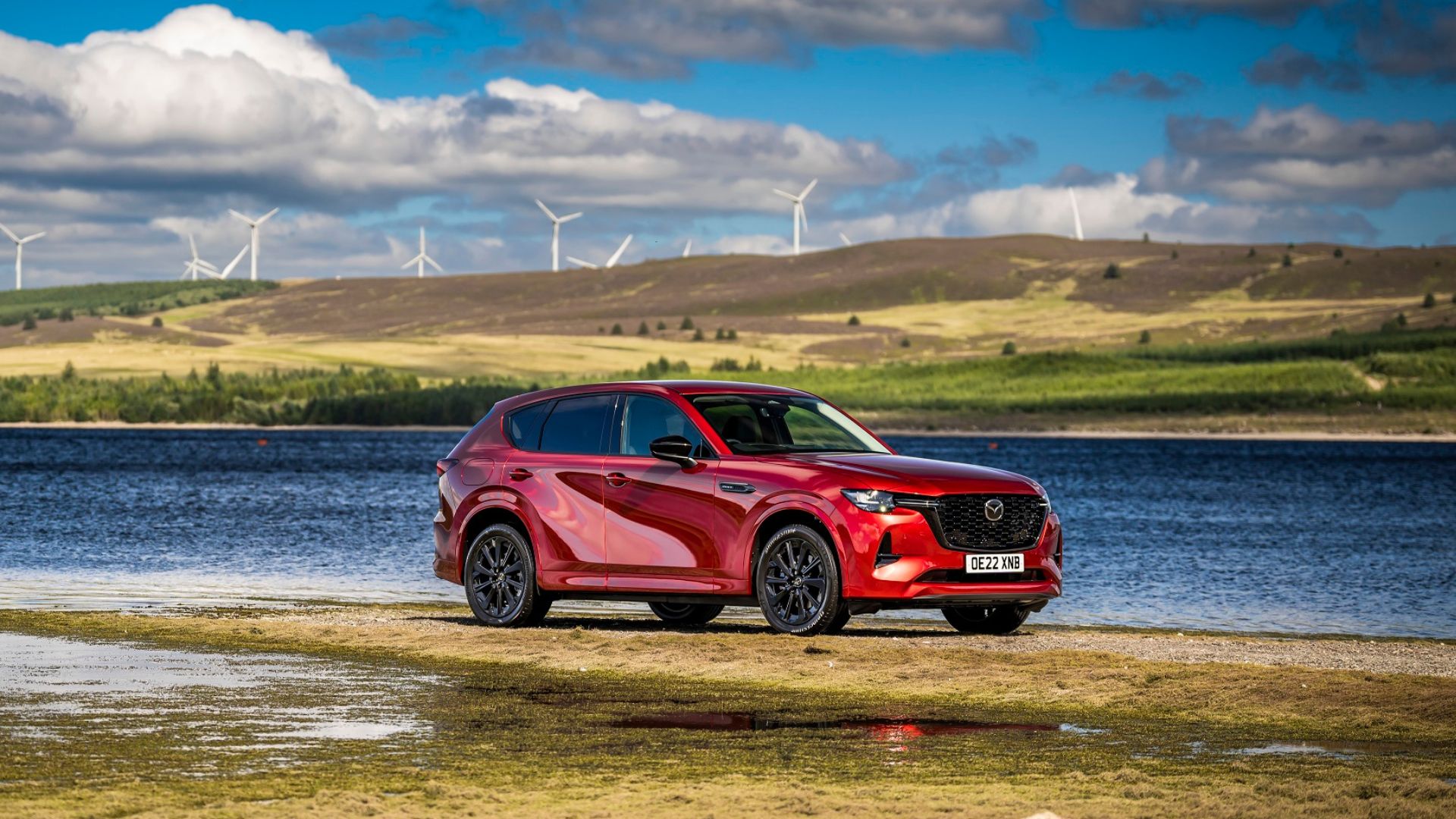 Red rear-wheel drive SUV in front of lake