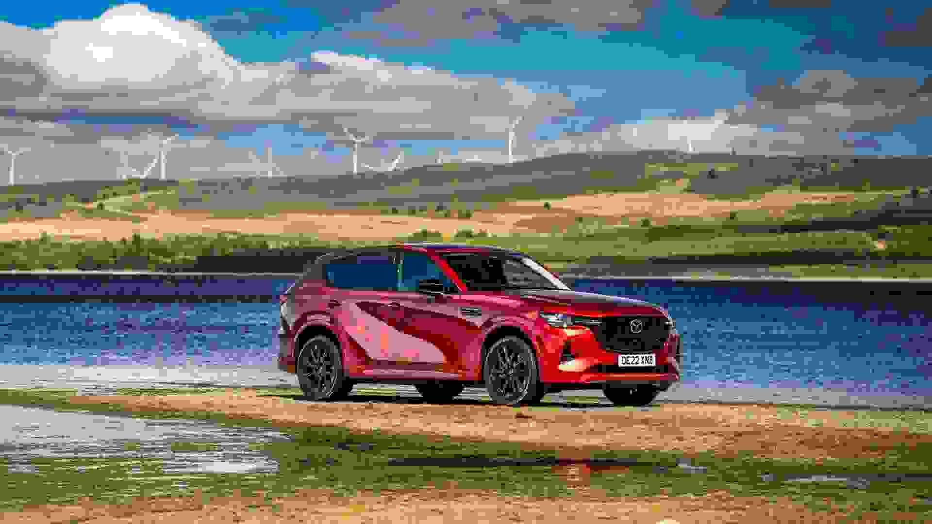 Red rear-wheel drive SUV in front of lake