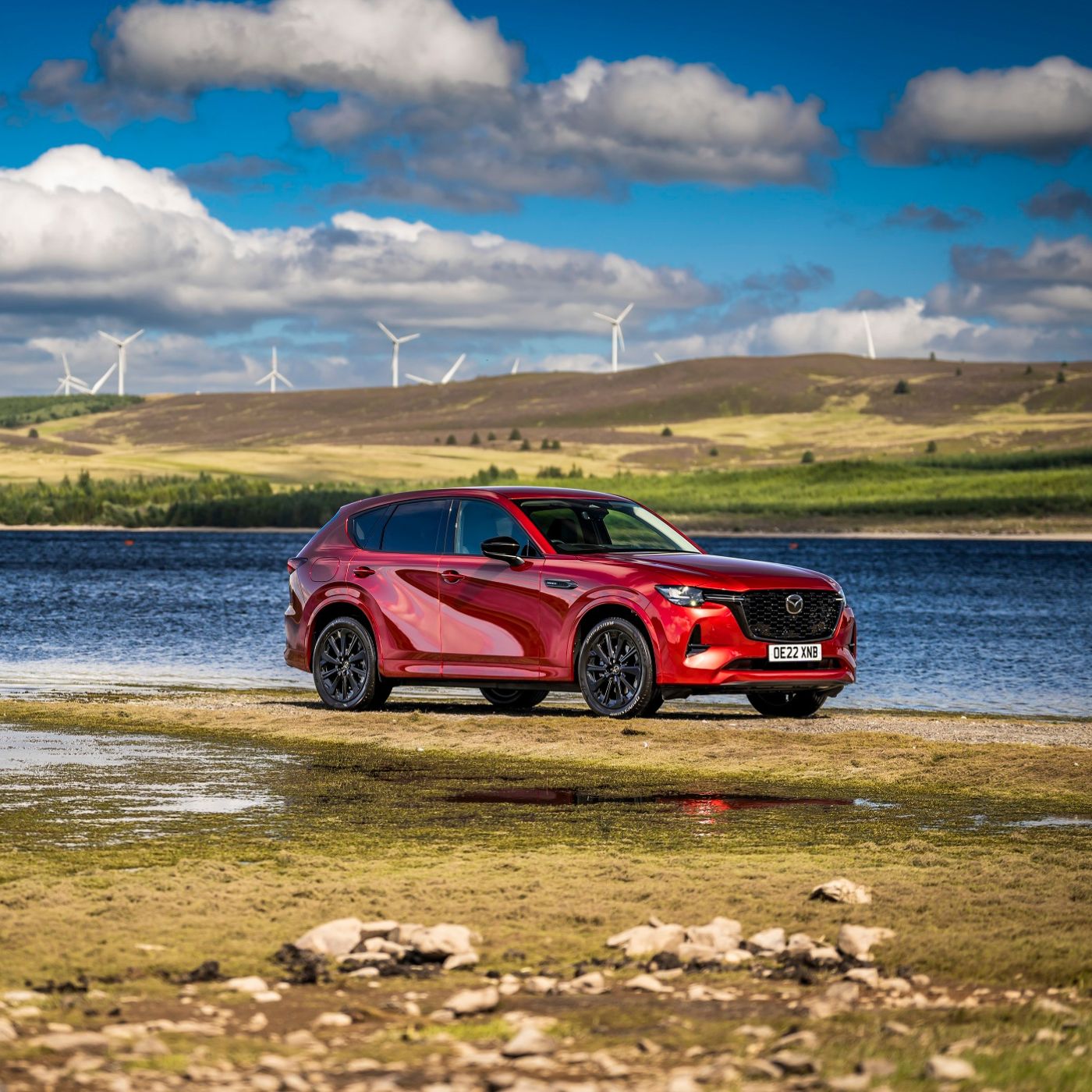 Red rear-wheel drive SUV in front of lake